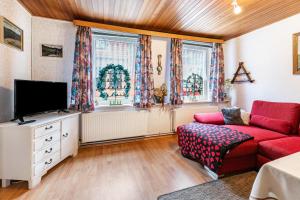 a living room with a red couch and a tv at Altstadt Ferienhaus mit Terrasse in Husum