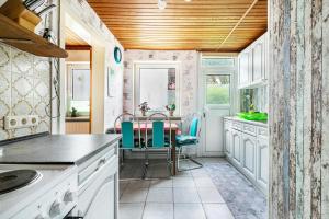 a kitchen with white cabinets and a table with chairs at Altstadt Ferienhaus mit Terrasse in Husum