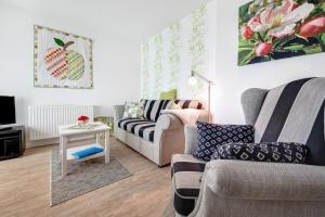 a living room with two couches and a table at Fewo Birkenallee - Apfel in Deinste