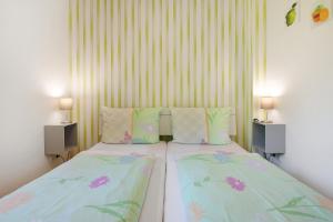 a bedroom with two beds and two lamps on both sides at Fewo Birkenallee - Apfel in Deinste