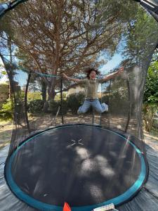a young girl sitting on top of a trampoline at Maison ROMIA in Fréjus