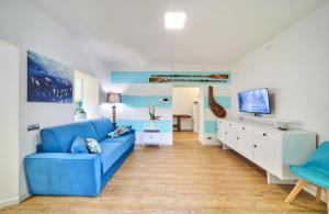a living room with a blue couch and a television at El Lavandee in Varenna