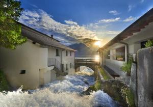 a bridge over a river with the sun in the sky at El Lavandee in Varenna