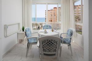 a dining room with a table and chairs and a window at Estudio Bloque 80 in Torrox