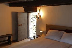 a bedroom with a bed and a door with a window at Casa Elena Rustico storico a Corippo in Corippo