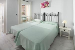 a bedroom with two beds with green sheets and a table at Estudio Bloque 80 in Torrox +15 photos