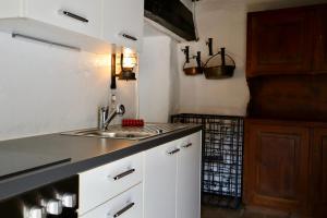 a kitchen with white cabinets and a sink at Casa Elena Rustico storico a Corippo in Corippo +32 photos