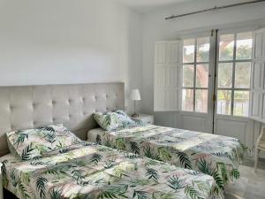 a bedroom with two beds and a window at Penthouse Jacaranda in Estepona +27 photos