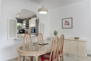 a dining room with a table and chairs and a kitchen at Penthouse Jacaranda in Estepona