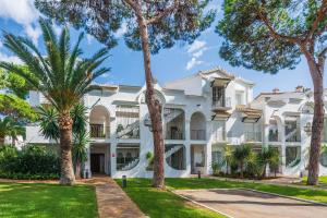 a large white building with palm trees in front of it at Penthouse Jacaranda in Estepona