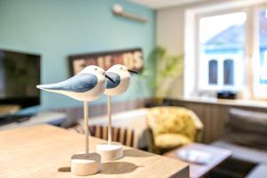 two birds sitting on a table in a living room at Klönstuv in Breklum