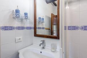 a white bathroom with a sink and a mirror at Domino Cottage - Monteggiori in Camaiore