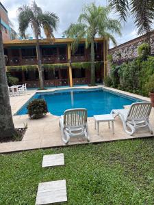 a swimming pool with two chairs and a table at AGUAMARINA SPA Y APART in Formosa