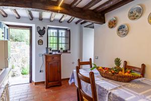 a kitchen and dining room with a table with a bowl of fruit at Domino Cottage - Monteggiori in Camaiore +16 photos