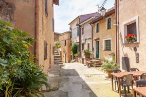 an alley in an italian town with tables and chairs at Domino Cottage - Monteggiori in Camaiore