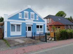 a blue house on the side of a street at Klönstuv in Breklum