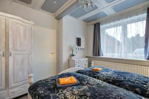 a bedroom with two beds and a large window at Klönstuv in Breklum