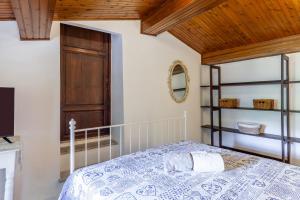 a bedroom with a bed and a wooden ceiling at Domino Cottage - Monteggiori in Camaiore