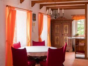 a dining room with a table and red chairs at Villa Lomba Bela Vista in Lomba