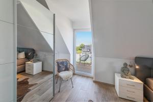 a small room with a chair and a bedroom at Haus Seeblick in Göhren-Lebbin