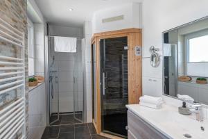 a bathroom with a shower and a sink and a mirror at Haus Seeblick in Göhren-Lebbin +27 photos