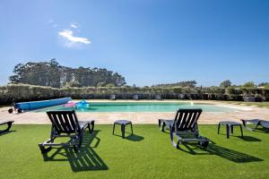 a swimming pool with two chairs and a slide at Apartamento Lomi com Piscina in Apúlia