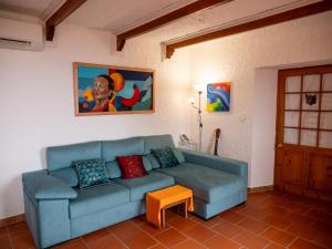 a living room with a blue couch and a table at Villa Lomba Bela Vista in Lomba