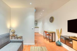 a living room with a couch and a flat screen tv at La Reine in Béziers
