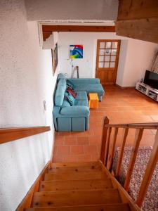a living room with a blue couch and a staircase at Villa Lomba Bela Vista in Lomba +54 photos