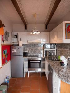 a kitchen with white cabinets and a silver refrigerator at Villa Lomba Bela Vista in Lomba