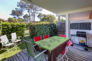 a patio with a table and chairs and a grill at Appartement Fred in Moliets-et-Maa