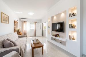 a white living room with a couch and a table at Absinthia Fanes in Rhodes Town