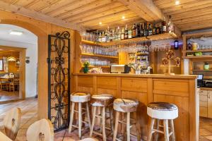 a kitchen with wooden cabinets and bar stools at Gasthaus Mamoosen in Penning +84 photos