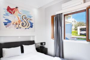 a bedroom with a bed and a painting on the wall at Anemi Leros Apartments 1 in Panteli