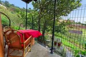 a table with a red table cloth on a fence at Luci's House B in São Jorge