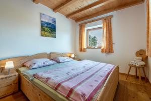 a bedroom with a large bed in a room with a window at Ferienwohnung Toni II in Siusi