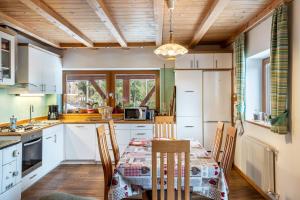 a kitchen with white cabinets and a table with chairs at Ferienwohnung Toni II in Siusi