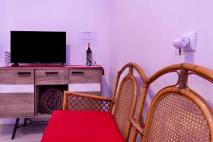 a living room with two chairs and a television at Luci's House B in São Jorge