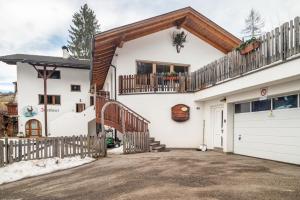 a white house with a balcony and a driveway at Ferienwohnung Toni II in Siusi