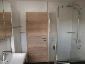 a shower with a wooden door in a bathroom at Wiesenblick in Brilon +34 photos