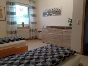 a bedroom with a bed and a dresser and a window at Wiesenblick in Brilon
