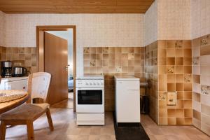 a kitchen with a stove and a refrigerator at Ferienwohnung Alberto in Drelsdorf