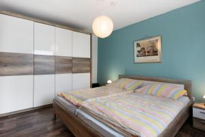 a bedroom with a bed and a blue wall at Ferienwohnung Alberto in Drelsdorf