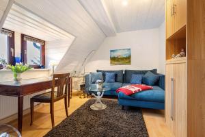 a living room with a blue couch and a table at Buchhaus Vier - Dachgeschoss in Kirchenlamitz