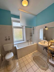 a bathroom with a tub and a toilet and a sink at Arminos Apartment Li in Chemnitz +14 photos