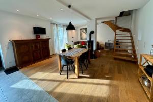 a living room with a dining room table and a staircase at Gut Wenne in Eslohe
