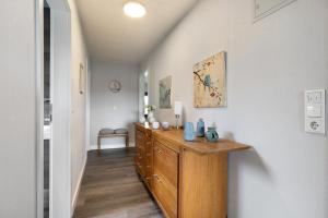 a hallway with a wooden dresser in a house at Ferienwohnung Helga Bauch in Klanxbüll +19 photos