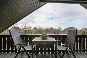 two chairs and a table on a deck at Ferienwohnung Helga Bauch in Klanxbüll