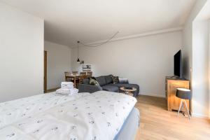 a living room with a bed and a couch at Hodderup Wohnung 10 in Husby +6 photos