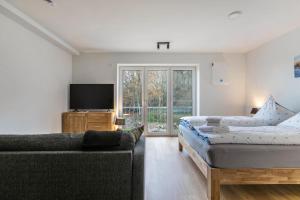 a living room with a bed and a couch at Hodderup Wohnung 10 in Husby